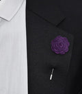 Purple floral lapel pin on a black suit jacket