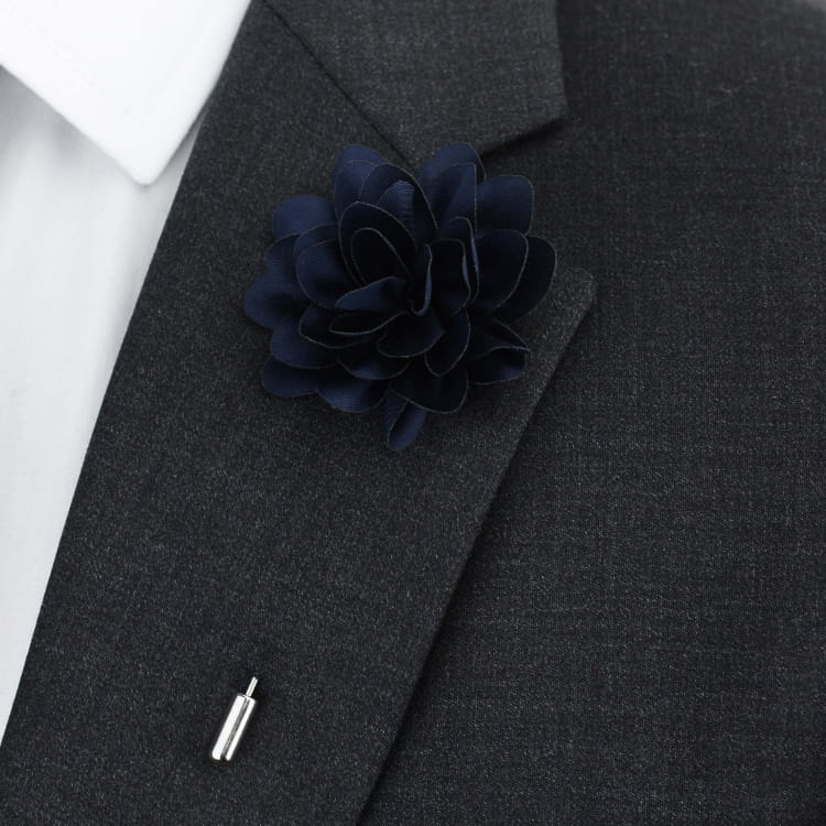 Navy blue floral lapel pin on a gray suit jacket