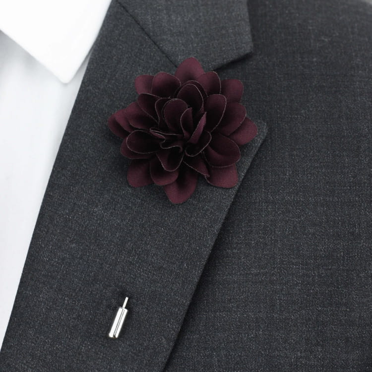 Dark purple flower lapel pin on a gray suit jacket