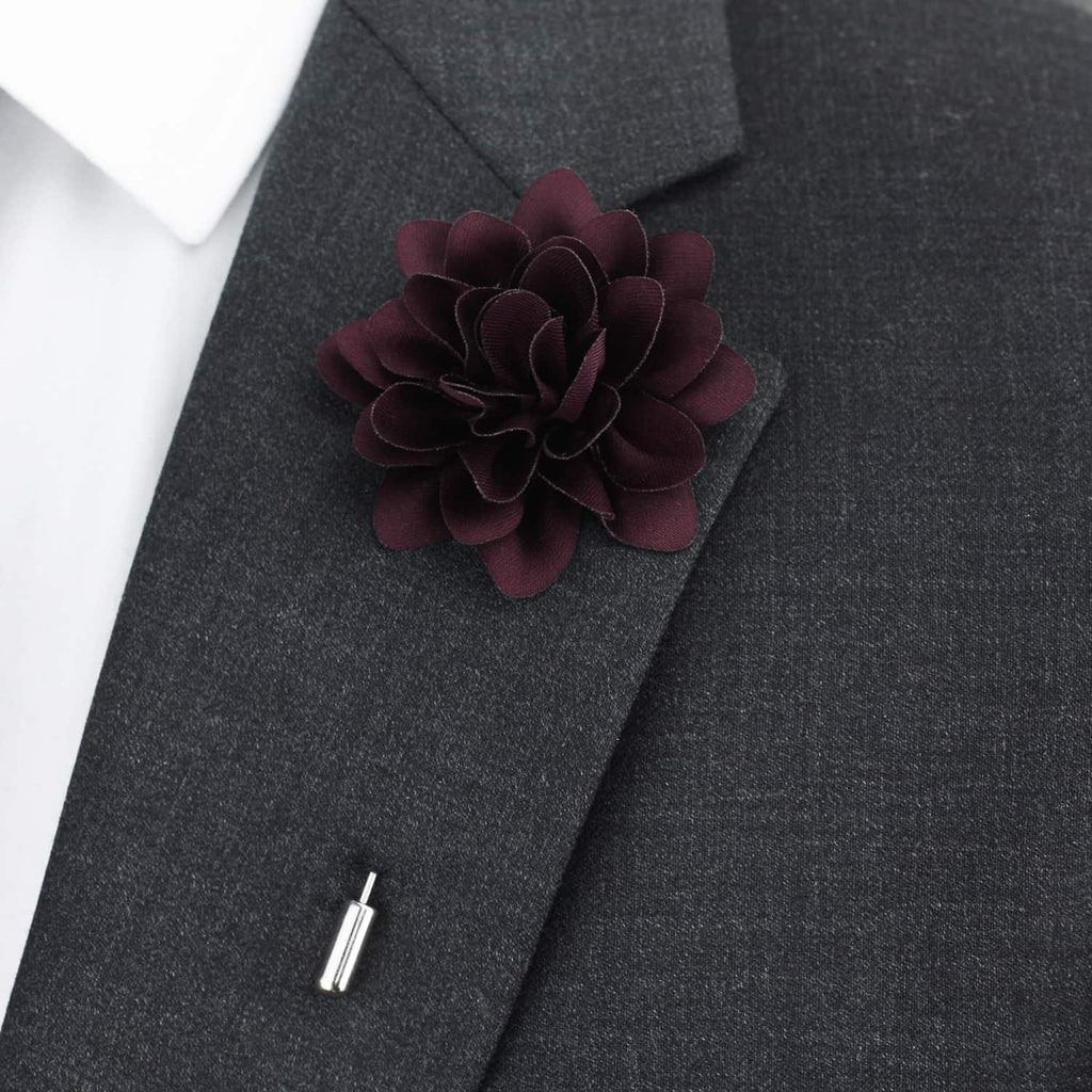 Dark purple flower lapel pin on a gray suit jacket