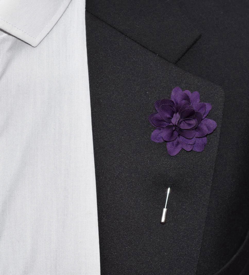 Purple floral lapel pin on a black suit jacket