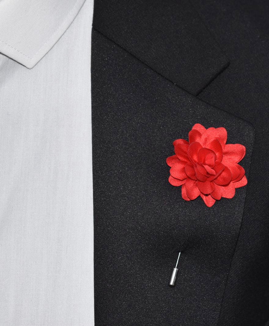 Red flower lapel pin on a black suit jacket