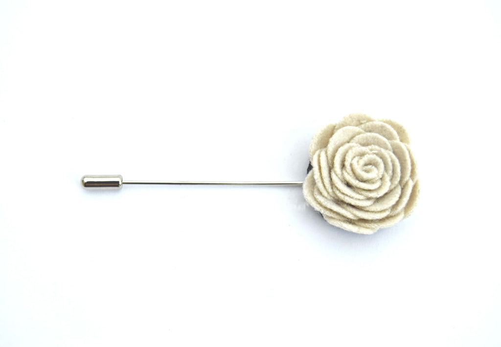 Cream-colored flower lapel pin on a white background