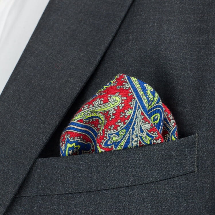 Colorful paisley pocket square in a dark gray suit pocket