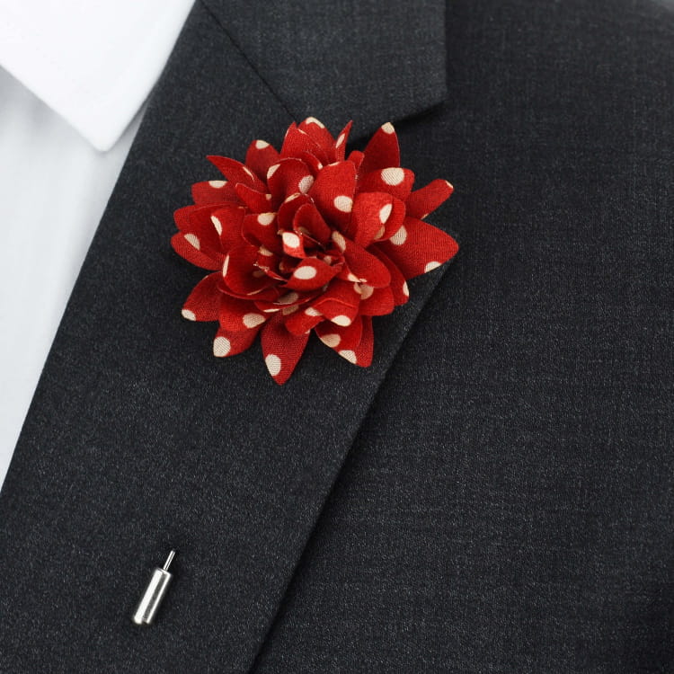 Red flower lapel pin on a black suit jacket