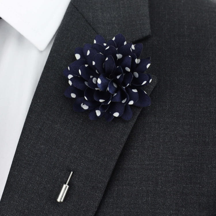 Navy blue flower lapel pin on a dark gray suit jacket