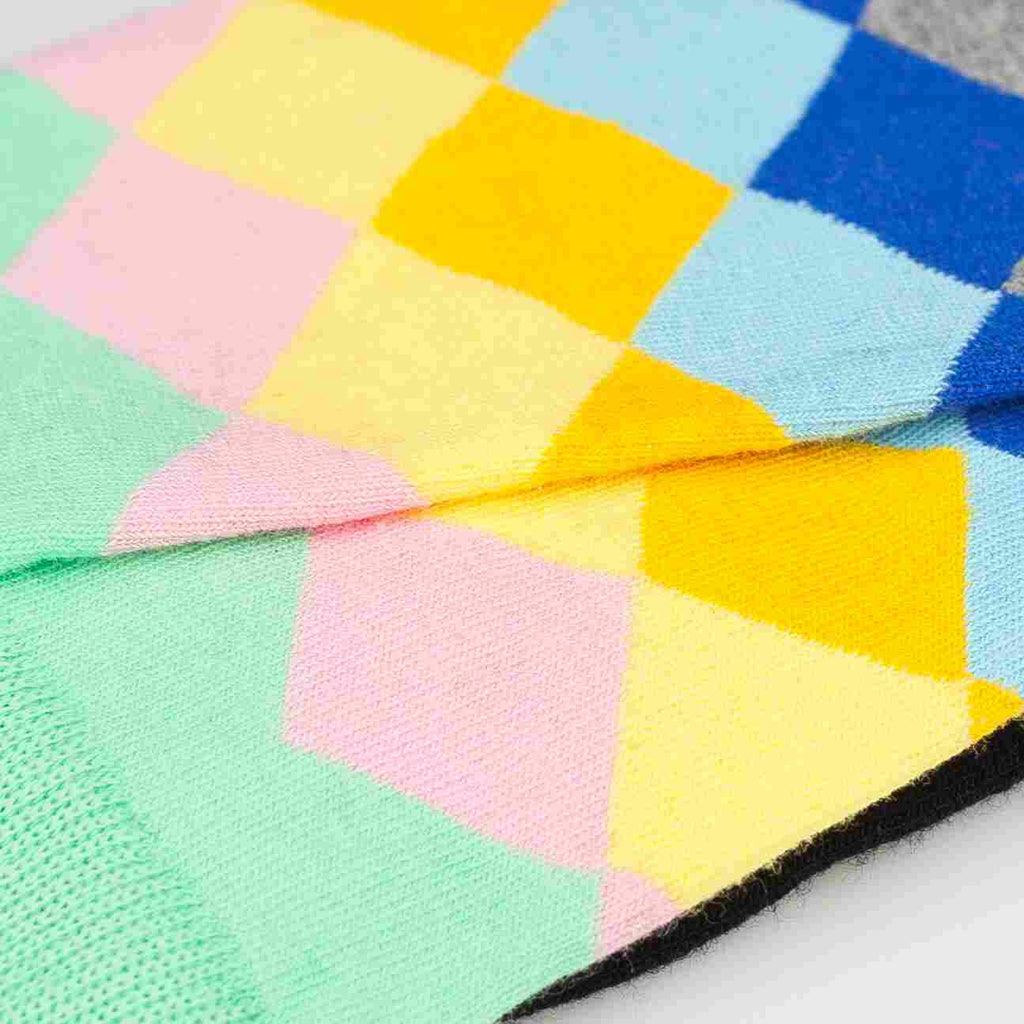 Close-up of a colorful geometric-patterned rug with pastel colors.