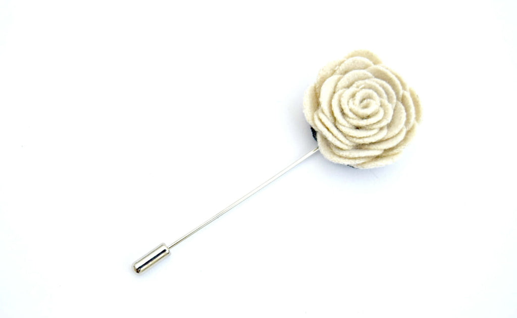 Cream-colored flower lapel pin on a white background