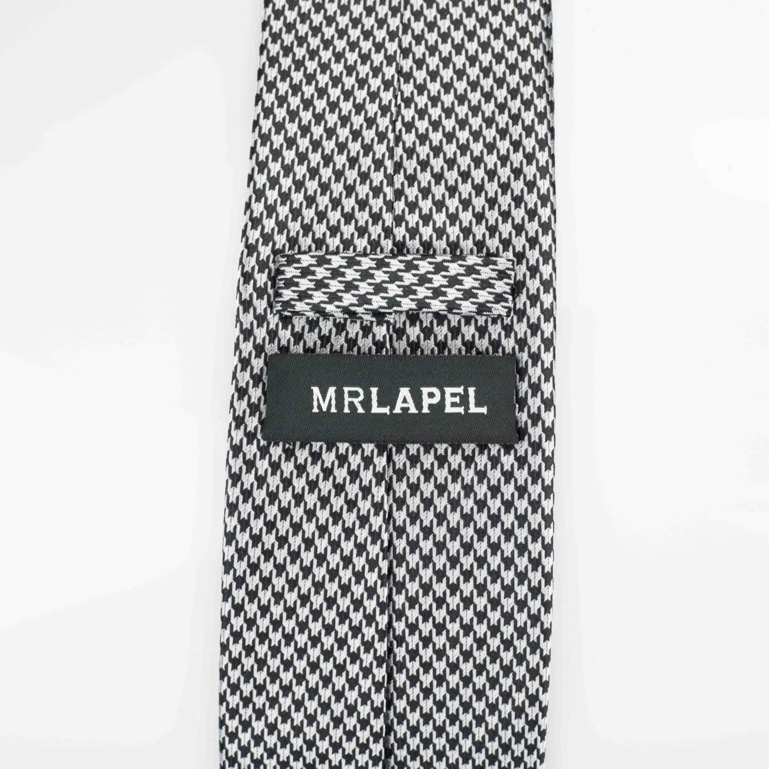Reverse of grey silk tie photographed against a white backdrop