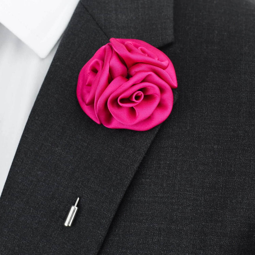 Pink rose-shaped lapel pin on a black suit jacket