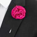 Pink rose-shaped lapel pin on a black suit jacket