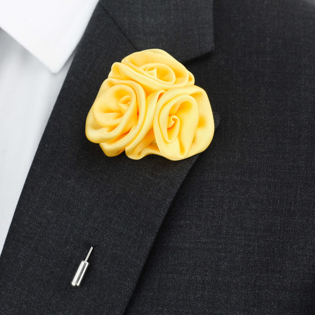 Yellow rose-shaped lapel pin on a black suit jacket