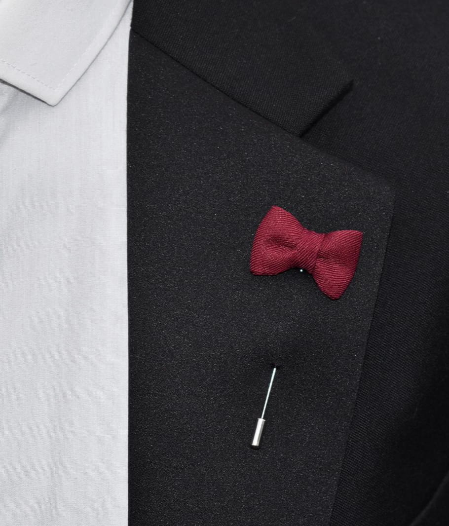 Red bow tie pin on a black suit jacket