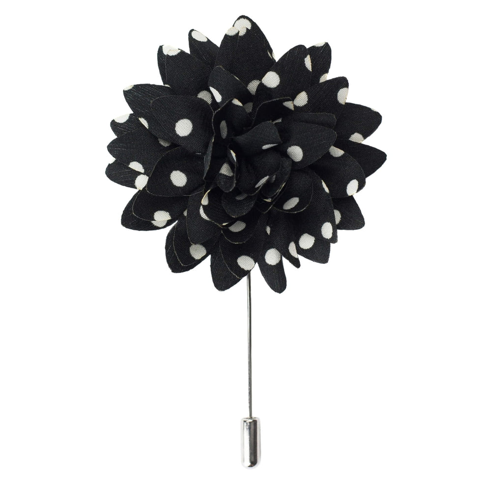 Black flower-shaped brooch with white polka dots on a white background