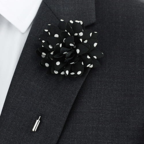 Black lapel flower with white polka dots on a black suit jacket