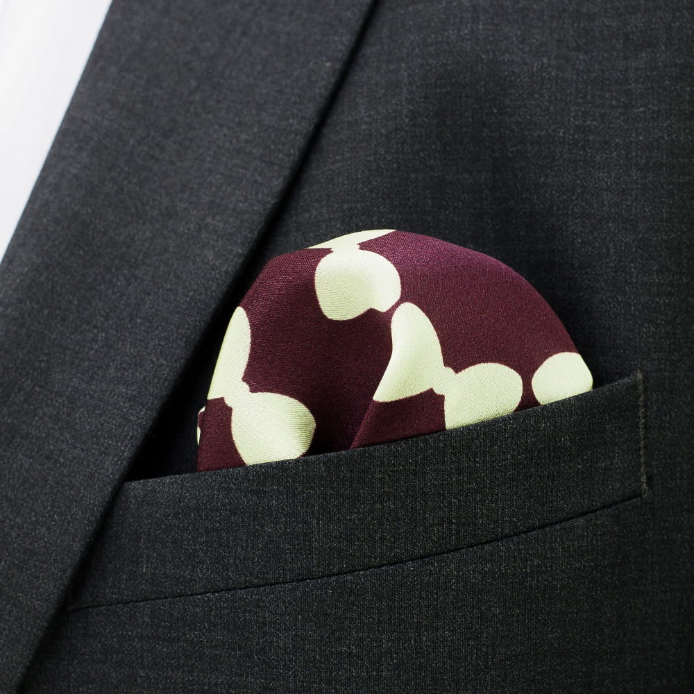 Maroon pocket square with white floral pattern in a suit pocket
