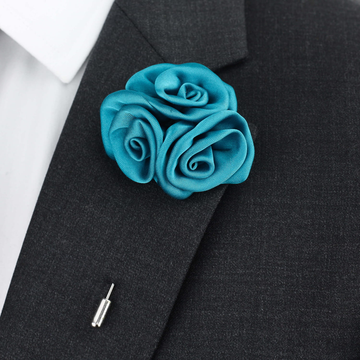 Turquoise rose lapel pin on a black suit jacket