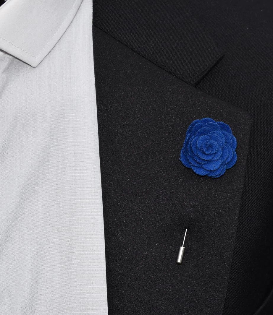 Blue flower lapel pin on a black suit jacket