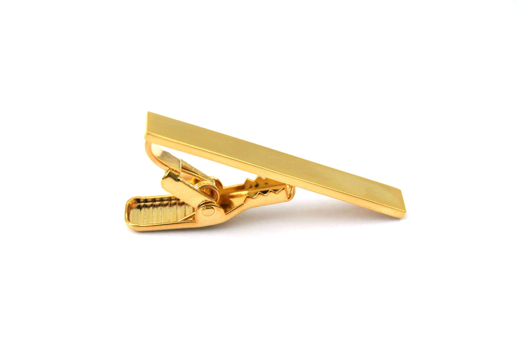 Gold tie clip on a white background