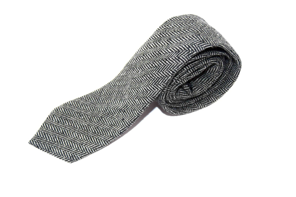 Folded gray tie with a subtle pattern on a white background