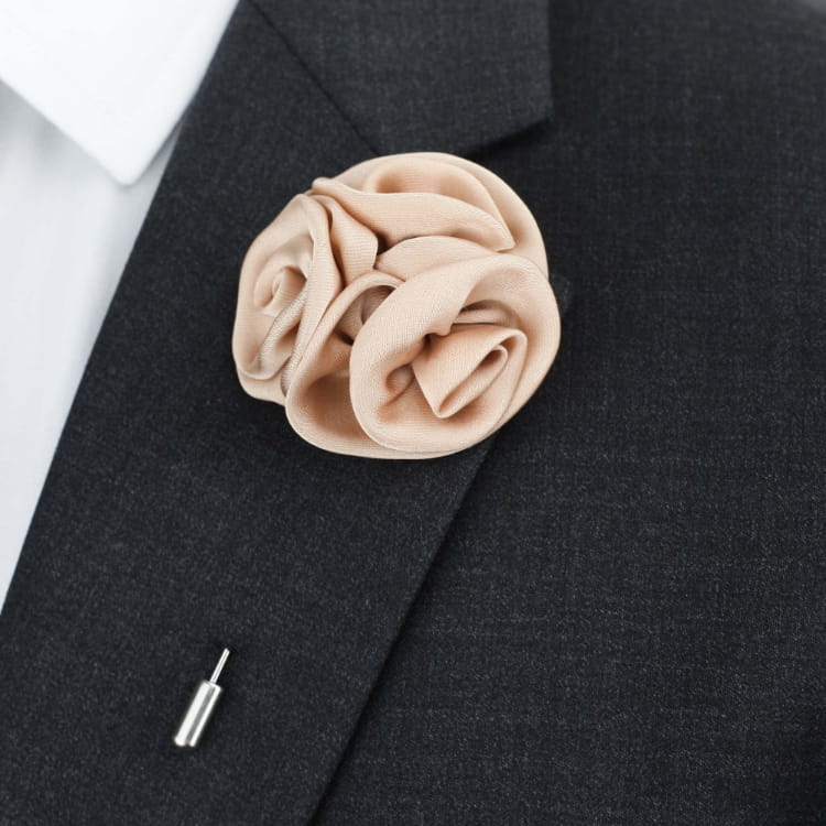 Beige floral lapel pin on a black suit jacket