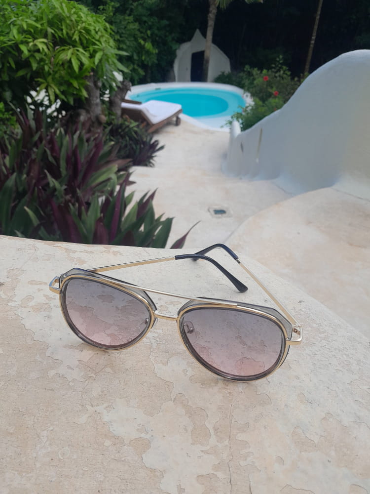 Pink and blue sunglasses next to a pool