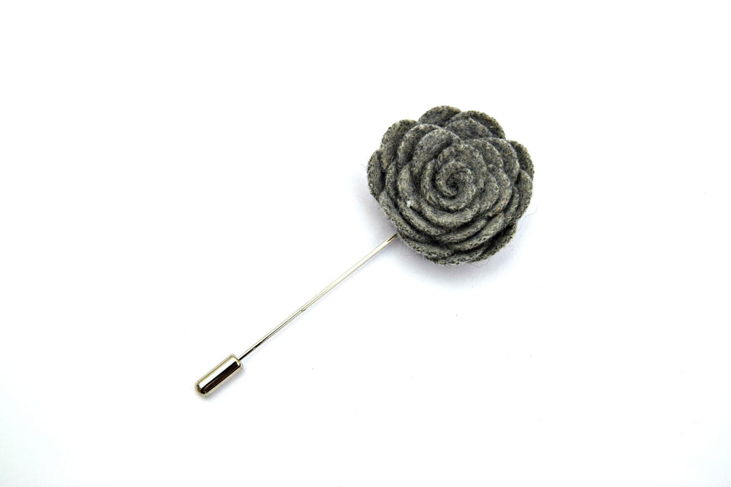 Gray flower-shaped lapel pin on a white background
