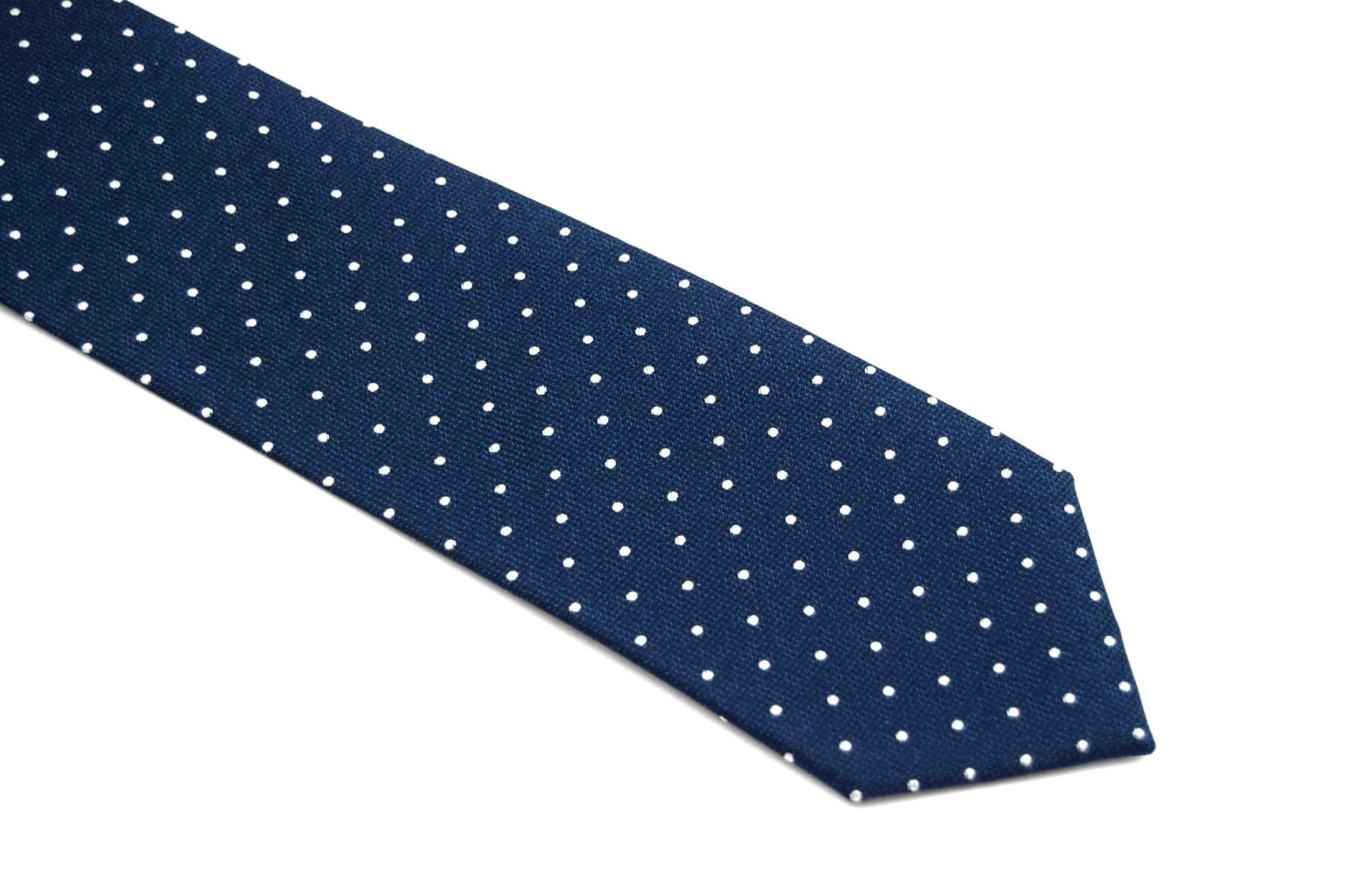 Blue polka dot tie with white spots against a white backdrop