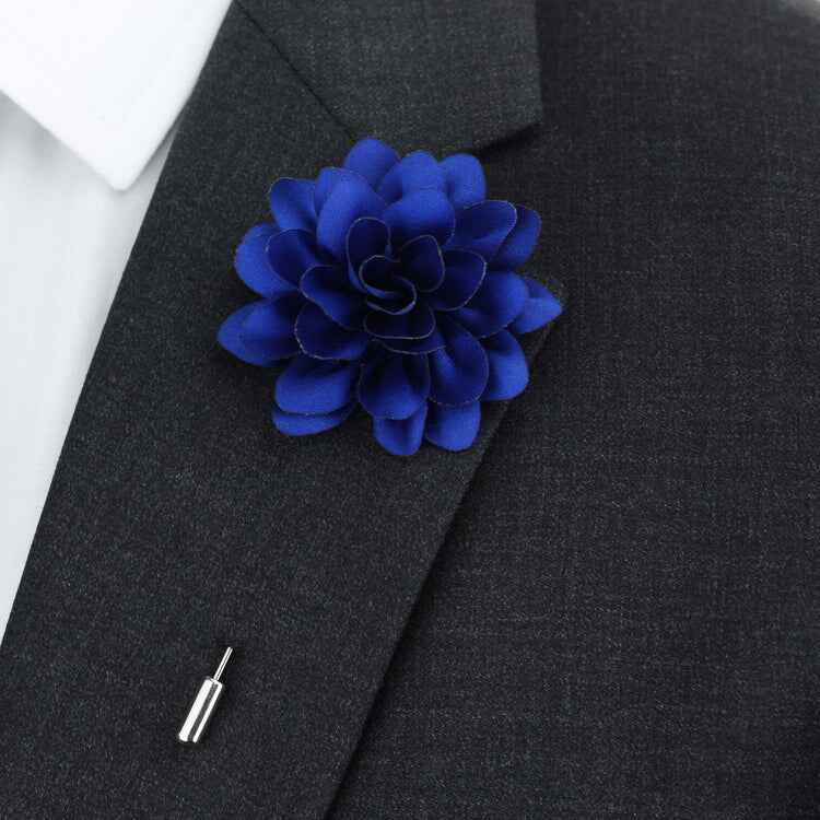Blue flower lapel pin on a dark suit jacket
