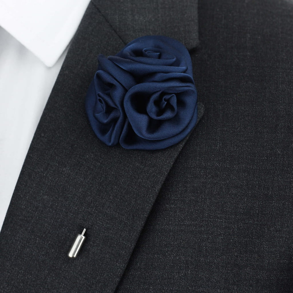 Navy blue rose lapel pin on a dark gray suit jacket