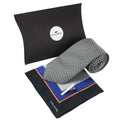 selection of men's gifts presented as a gift set, including a silver tie, a pocket square with black, orange, blue and grey motif, and a silver tie clip