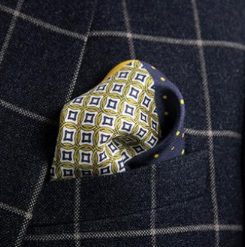 Blue and mustard pocket square with four distinctive quadrants for you to choose from, including a paisley design, a bold mustard square, a blue and yellow polka dot pattern, and a classic geometric pattern in blue and mustard 
