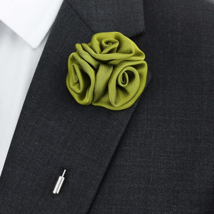 Green floral lapel pin on a dark suit jacket