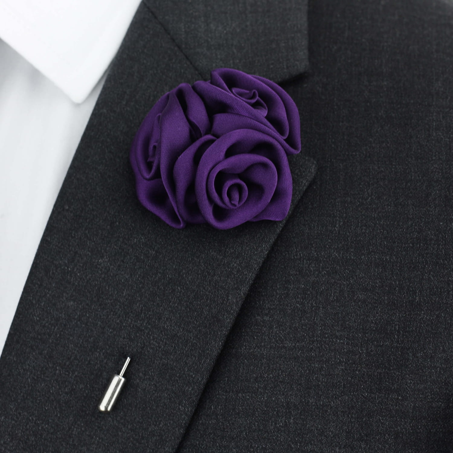 Purple rose lapel pin on a dark suit jacket